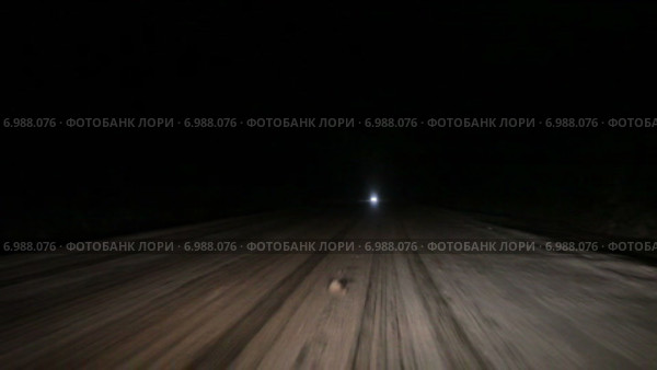 Автомобиль едет по заснеженной северной ночной дороге, огни встречного транспорта. Автострада Кола. Стоковое видео, видеограф Кекяляйнен Андрей / Фотобанк Лори