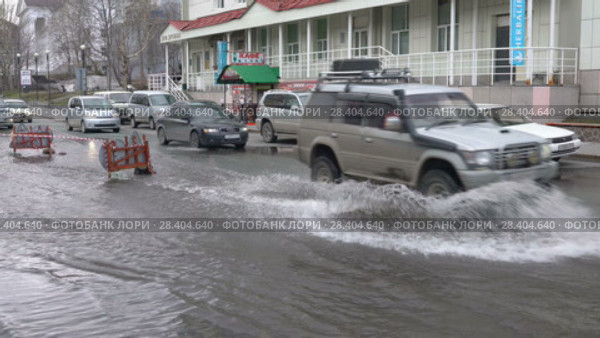 Автомобили едут по луже на улице города (2018 год). Редакционное видео, видеограф А. А. Пирагис / Фотобанк Лори