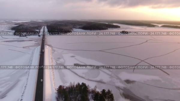 Автомобили проезжают по автомобильной дороге Кола через реку Сегежа. Зима, закат солнца. Карелия. Стоковое видео, видеограф Кекяляйнен Андрей / Фотобанк Лори