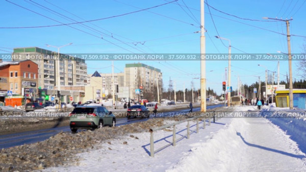 Автомобили в замедленной съемке на шоссе, останавливаются на красный свет светофора на пешеходном переходе в городе весной. Редакционное видео, видеограф Sergei Gorin / Фотобанк Лори