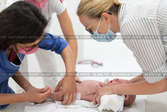 Baby beeing vaccinated by pediatrician in presence of his mother. Preventive vaccination against Diphtheria, whooping cough, tetanus, hepatitis, haemophilus influenzae, pneumococcus, poliomyelitis. Стоковое фото, фотограф Matej Kastelic / Фотобанк Лори