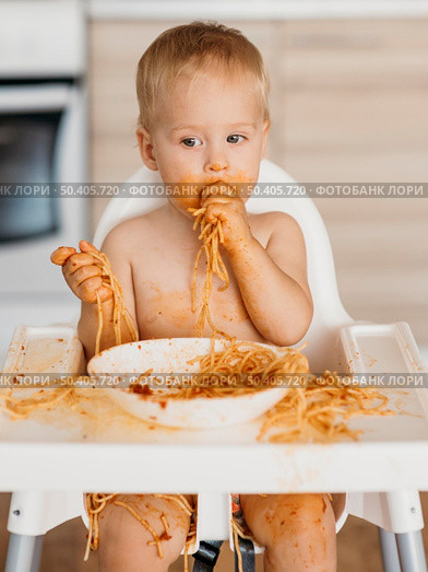 baby boy making mess with pasta alone. Стоковое фото, агентство Ingram Publishing / Фотобанк Лори
