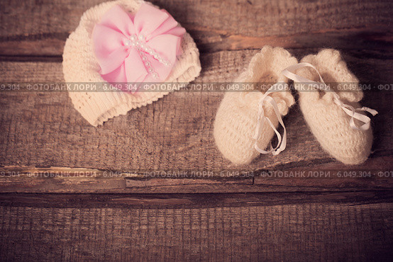 baby's bootee and cap on wooden background. Стоковое фото, фотограф Майя Крученкова / Фотобанк Лори