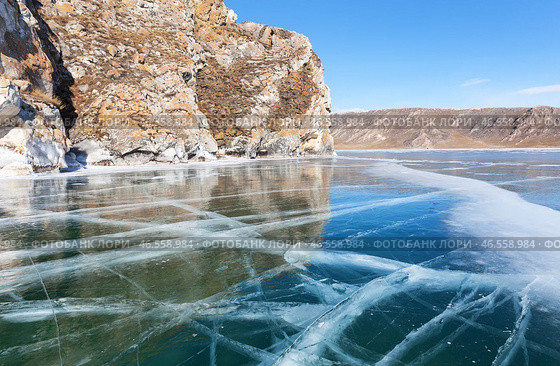 Baikal Lake in February sunny day. Beautiful winter landscape with blue smooth ice with cracks near Shibete mountain at Ust-Anga Bay. Natural background. Ice travels and outdoor recreation. Стоковое фото, фотограф Виктория Катьянова / Фотобанк Лори