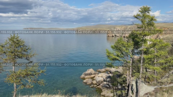 Baikal Lake on sunny summer day. Video of shallow bay of Small Sea and  beach of Olkhon island. Scenic landscape with larch trees. Natural background. Summer travels. Стоковое видео, видеограф Виктория Катьянова / Фотобанк Лори