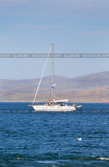 BAIKAL LAKE, SAKHYURTA VILLAGE, IRKUTSK REGION, RUSSIA - August 14, 2023: Tourists rest with their family on pleasure sailing yacht and travel along rocky shore of Olkhon Island. Summer holyday. Редакционное фото, фотограф Виктория Катьянова / Фотобанк Лори