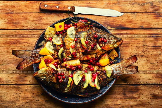 Baked carp with fruits, berries and spices. Grilled seafood. Delicious carp grilled with kiwi and mango. Стоковое фото, агентство Ingram Publishing / Фотобанк Лори