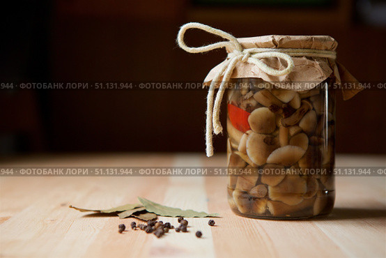 Bank of pickled mushrooms honey agarics standing on a wooden table surface. Стоковое фото, фотограф Наталия Кирсанова / Фотобанк Лори