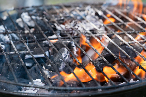 Barbecue Fire Grill close-up, empty flaming charcoal grill with open fire, ready for product placement.. Barbecue Fire Grill close-up. Стоковое фото, агентство Ingram Publishing / Фотобанк Лори