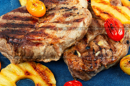 Barbecue steak with pineapples. Grilled meat,roasted with pineapple. Grilled steak and ananas.. Grilled pork loin steak, bbq. Стоковое фото, агентство Ingram Publishing / Фотобанк Лори