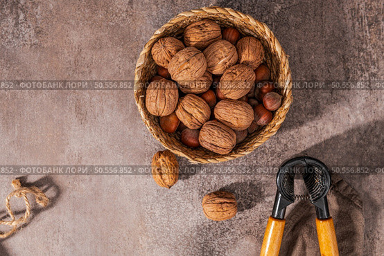 Basket with walnuts and hazelnuts and a nut cracker on a rustic kitchen counter. Стоковое фото, агентство Ingram Publishing / Фотобанк Лори
