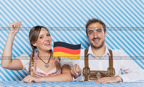 bavarian friends holding german flag. Стоковое фото, агентство Ingram Publishing / Фотобанк Лори