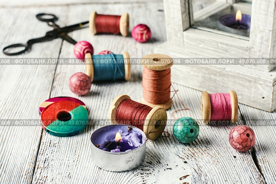 Beads and spools of thread for needlework on bright background. Accessories for home crafts. Стоковое фото, агентство Ingram Publishing / Фотобанк Лори