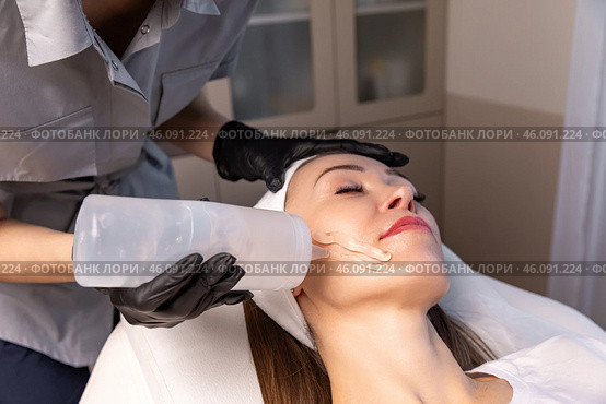 Beautician applies gel to woman face before beauty treatment, removing pigmentation at cosmetic clinic. Phototherapy, photorejuvenation, IPL in a beauty salon. Skin care concept. High quality photo. Стоковое фото, фотограф Ирина Михайличенко / Фотобанк Лори