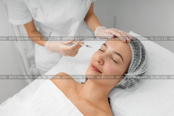 beautician doing injection filler female client salon. Стоковое фото, агентство Ingram Publishing / Фотобанк Лори