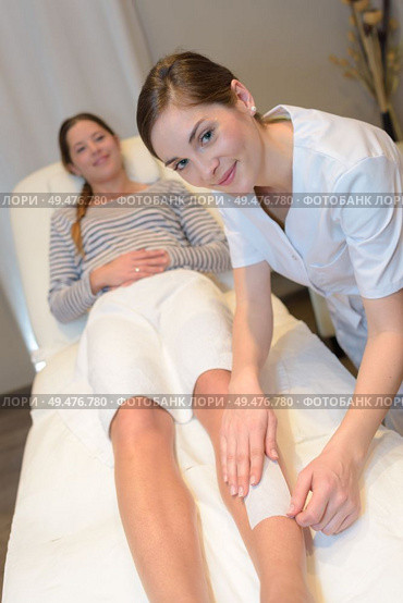 beautician waxing woman a leg at salon. Стоковое фото, агентство Ingram Publishing / Фотобанк Лори