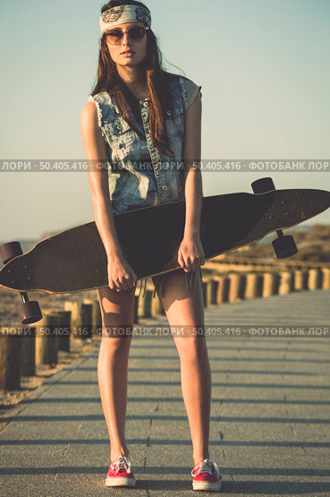Beautiful and fashion young woman posing with a skateboard. Стоковое фото, агентство Ingram Publishing / Фотобанк Лори