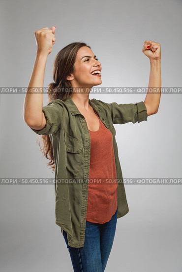 Beautiful and successful young woman with arms raised. Стоковое фото, агентство Ingram Publishing / Фотобанк Лори