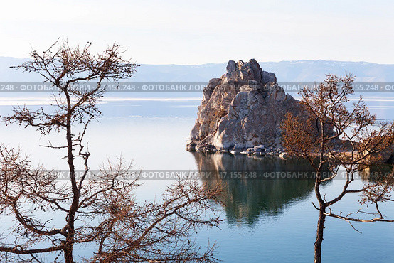 Beautiful calm landscape of Baikal Lake on May evening. View from coast of Olkhon Island to famous Shamanka Rock or Burkhan Cape - natural landmark of lake. Natural background. Spring travels. Стоковое фото, фотограф Виктория Катьянова / Фотобанк Лори