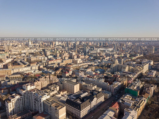 Beautiful cityscape of old and modern buildings, the roads of Kiev against the blue sky. Aerial photograph of the Olympic sports complex in the distance. City landscape of Kiev with modern and old houses roads with cars, Ukraine. Drone photography. Стоковое фото, агентство Ingram Publishing / Фотобанк Лори