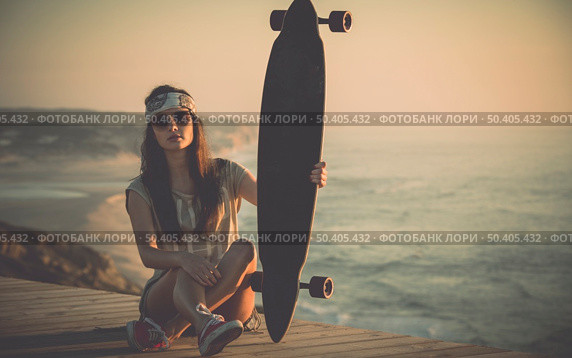 Beautiful fashion skater girl posing with  a skate board. Стоковое фото, агентство Ingram Publishing / Фотобанк Лори