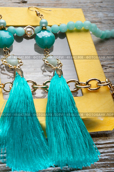 beautiful handmade  turquoise  jewelry with natural gems in yellow box around old style wooden background. macro shot. fashion concept. Стоковое фото, агентство Ingram Publishing / Фотобанк Лори