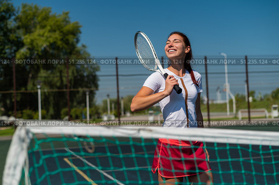 Beautiful smiling woman with a shadow from a tennis racket on her face on a sunny day. Стоковое фото, фотограф Михаил Решетников / Фотобанк Лори