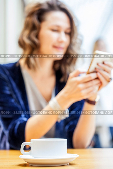 Beautiful smiling woman with a smartphone in her hands. Стоковое фото, фотограф Astroid / Фотобанк Лори