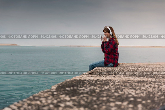 Beautiful woman enjoying her day in the lake with a mug of hot coffee. Стоковое фото, агентство Ingram Publishing / Фотобанк Лори