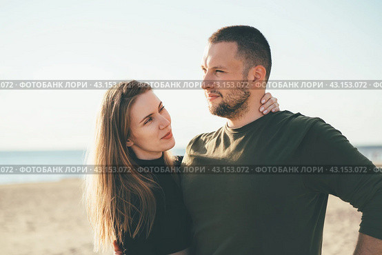Beautiful woman full of love looking to handsome convinced man embracing her. Стоковое фото, фотограф Natalia Gdovskaia / Фотобанк Лори