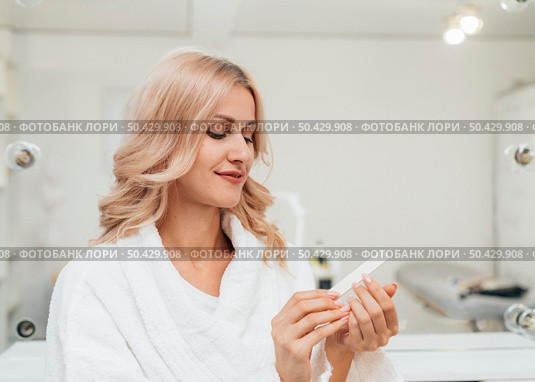 beautiful woman looking her healthy manicure. Стоковое фото, агентство Ingram Publishing / Фотобанк Лори