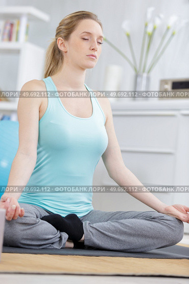 beautiful woman meditating at home in the lotus position. Стоковое фото, агентство Ingram Publishing / Фотобанк Лори