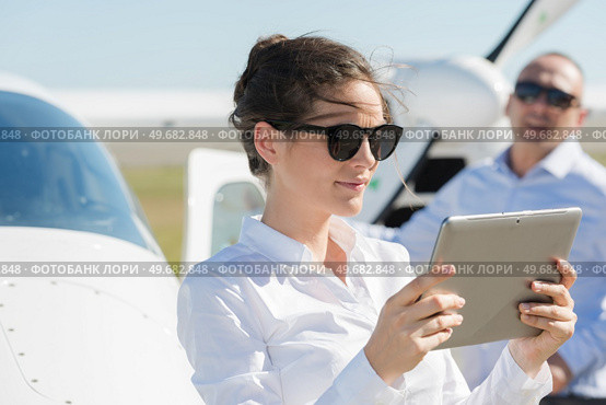 beautiful woman using tablet-pc at airfield. Стоковое фото, агентство Ingram Publishing / Фотобанк Лори
