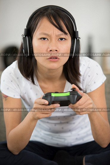 beautiful young asian woman engrossed in a computer game. Стоковое фото, агентство Ingram Publishing / Фотобанк Лори
