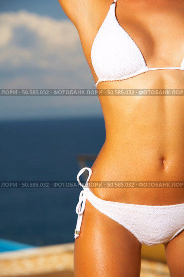 Beautiful young Sexy woman body in bikini during sunbath next to swimming pool. Стоковое фото, агентство Ingram Publishing / Фотобанк Лори