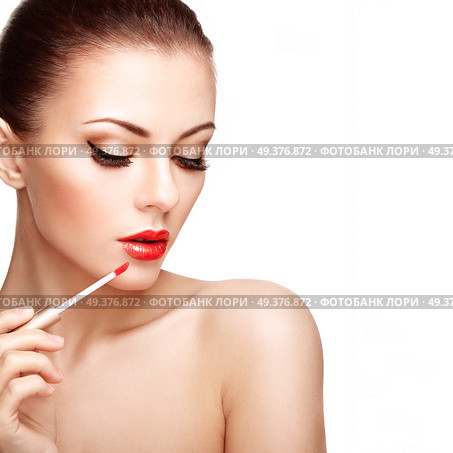 Beautiful Young Woman Paints Lips with Lipstick. Perfect Make-up. Beauty Fashion. Perfect Skin. Стоковое фото, агентство Ingram Publishing / Фотобанк Лори