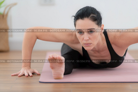 Beautiful young woman practicing yoga at home. Yoga asana. Стоковое фото, агентство Ingram Publishing / Фотобанк Лори