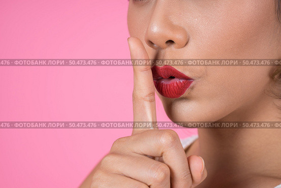 Beauty asian woman red lips and finger showing hush silence sign. Стоковое фото, агентство Ingram Publishing / Фотобанк Лори
