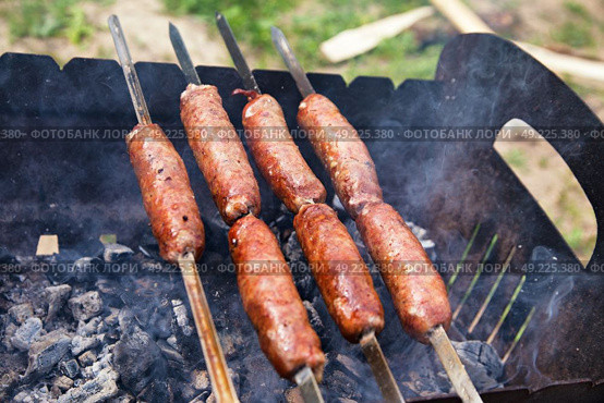 Beef sausages grilled on a coals. Outdoor kielbasa barbecue. Barbecue on brazier. Стоковое фото, агентство Ingram Publishing / Фотобанк Лори
