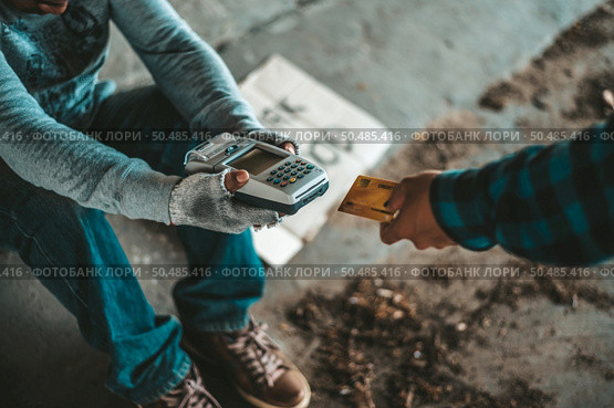 Beggars sitting under the overpass with a credit card and credit card swipe machine. Стоковое фото, агентство Ingram Publishing / Фотобанк Лори
