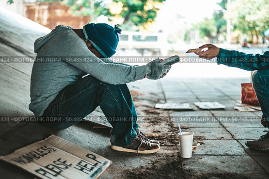 Beggars sitting under the overpass with a credit card and credit card swipe machine. Стоковое фото, агентство Ingram Publishing / Фотобанк Лори
