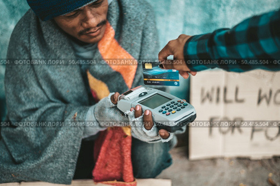 Beggars sitting under the overpass with a credit card and credit card swipe machine. Стоковое фото, агентство Ingram Publishing / Фотобанк Лори