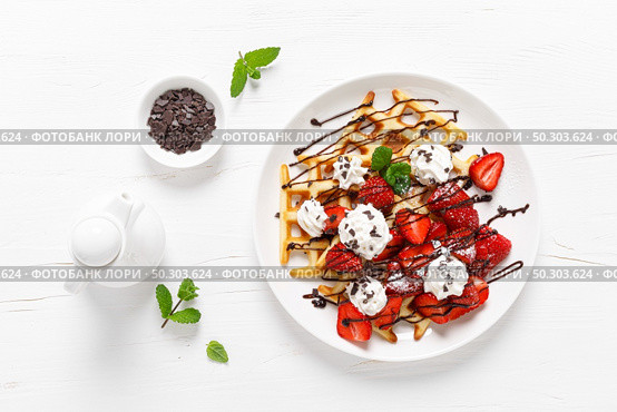 Belgian waffles with fresh strawberry, chocolate topping and whipped cream. Стоковое фото, агентство Ingram Publishing / Фотобанк Лори