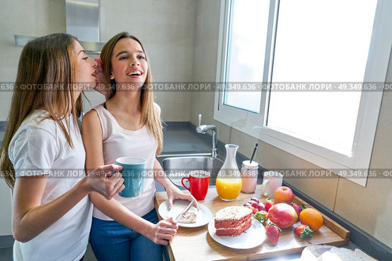 best friends girls teens breakfast in kitchen. best friends girls teens breakfast in kitchen whispering ear. Стоковое фото, агентство Ingram Publishing / Фотобанк Лори