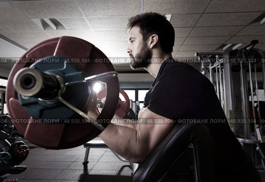 biceps preacher bench arm curl workout man at fitness gym. Стоковое фото, агентство Ingram Publishing / Фотобанк Лори