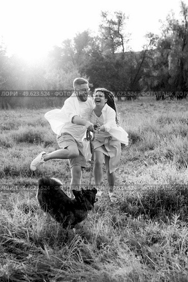 Big dog for a walk with a guy and a girl on the green prairie. Стоковое фото, агентство Ingram Publishing / Фотобанк Лори