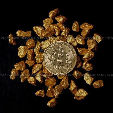 Bitcoin laying on stacked gold nuggets rendered on black background flat lay. Bitcoin as desirable as digital gold concept. Bitcoin cryptocurrency.. gold nuggets and Gold Bitcoin Coin on black background. Bitcoin cryptocurrency. Стоковое фото, агентство Ingram Publishing / Фотобанк Лори