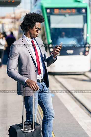 Black Businessman waiting for the next train. Man with afro hair commuting.. Black Businessman waiting for the next train. Стоковое фото, агентство Ingram Publishing / Фотобанк Лори