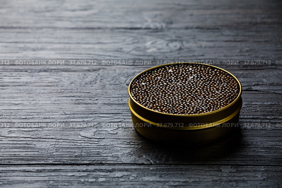 Black caviar in can on black wooden background copy space. Стоковое фото, фотограф Лисовская Наталья / Фотобанк Лори