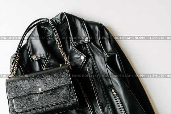 Black leather jacket with zippers and pockets and black leather stylish bag. Modern outerwear. Close-up. Fashion background. Autumn urban street clothes. Fashionable concept. Women's casual day outfit. Стоковое AI-изображение, AI-художник Марина Демидюк / Фотобанк Лори